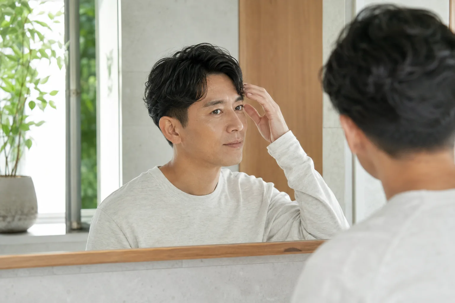 自宅で朝のセットを終え、鏡で自然な短髪を確認する日本人男性の生成イメージ